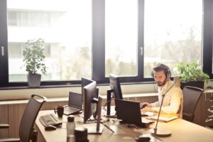 Tampa Business Broker with headphones facing a computer monitor.