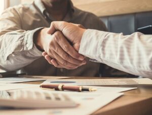 Two people shaking hands over a deal